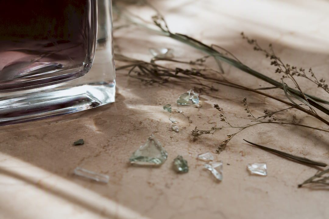 Zoom sur le verre recyclé et les ingrédients naturels utilisés dans la création de parfums.