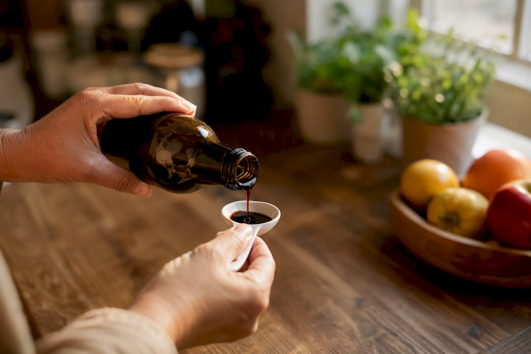 Hand measuring yacon syrup with teaspoon