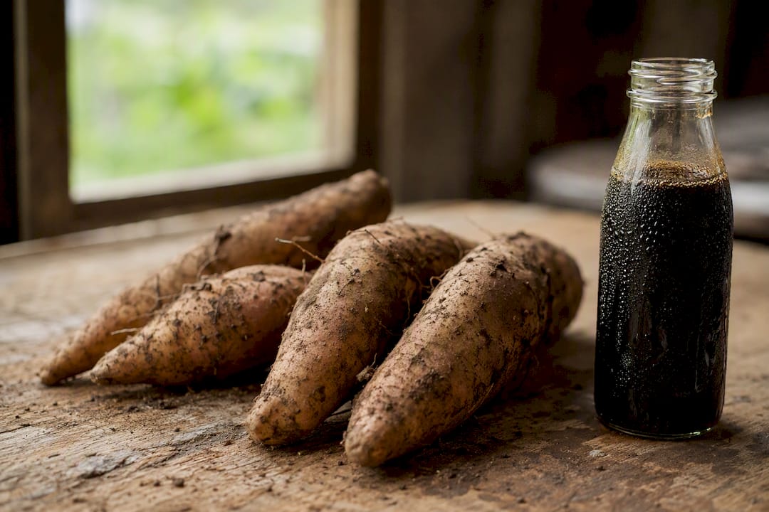 Yacon roots and syrup bottle on wooden table