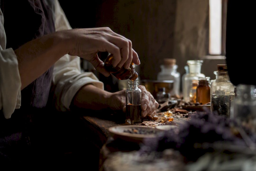 Mains d'artisan mélangeant des huiles essentielles