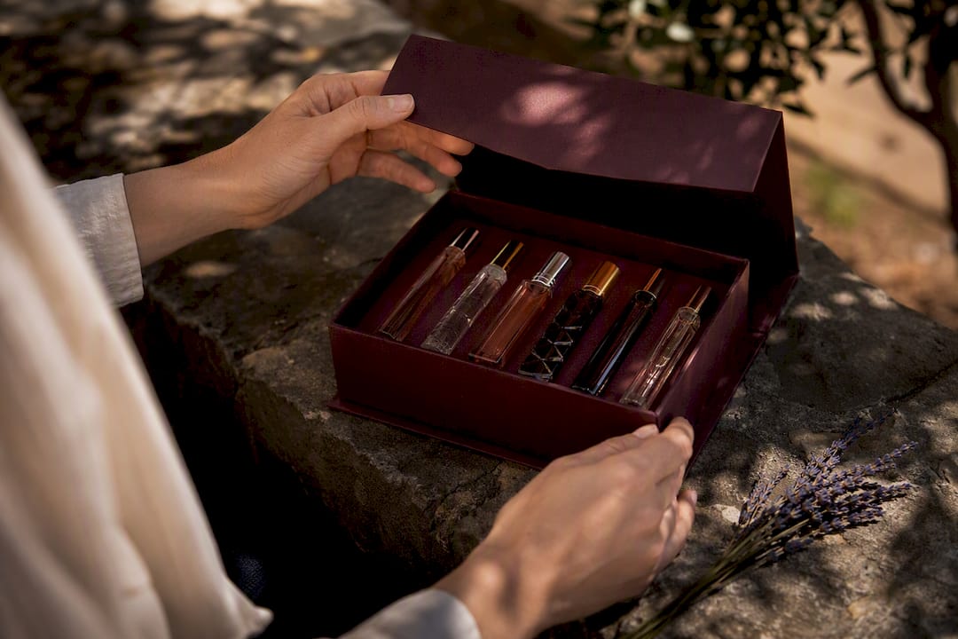 Hands opening elegant perfume gift box