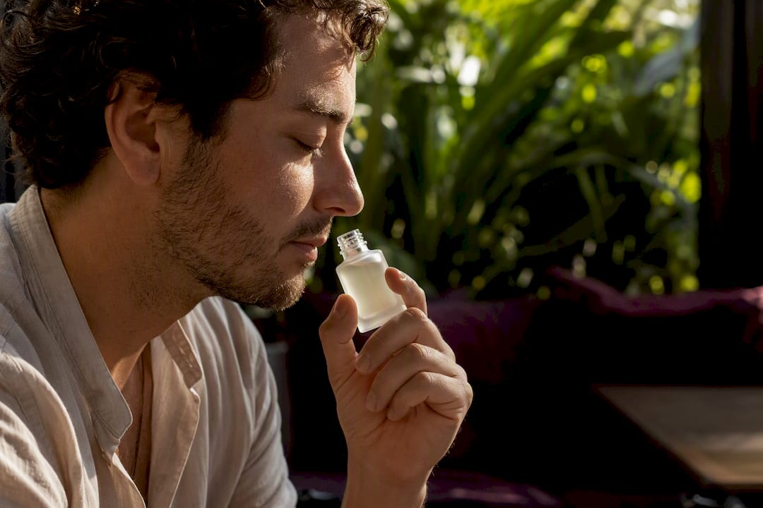 Persona oliendo una muestra de perfume de higo en un frasco