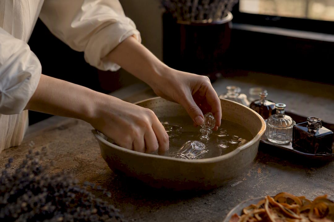 Glass perfume bottle parts soaking in vinegar