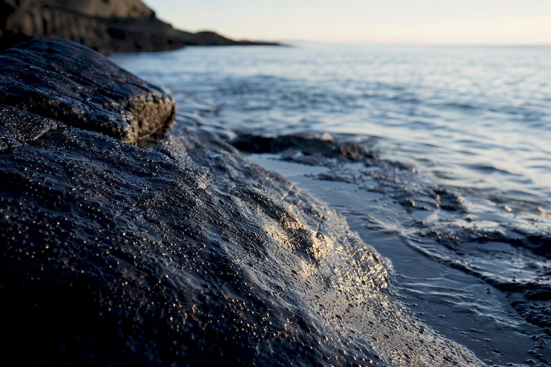 Sea spray over sun-warmed coastal stones