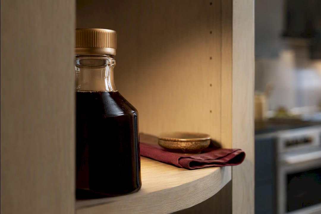 Partially cropped syrup container in shaded pantry