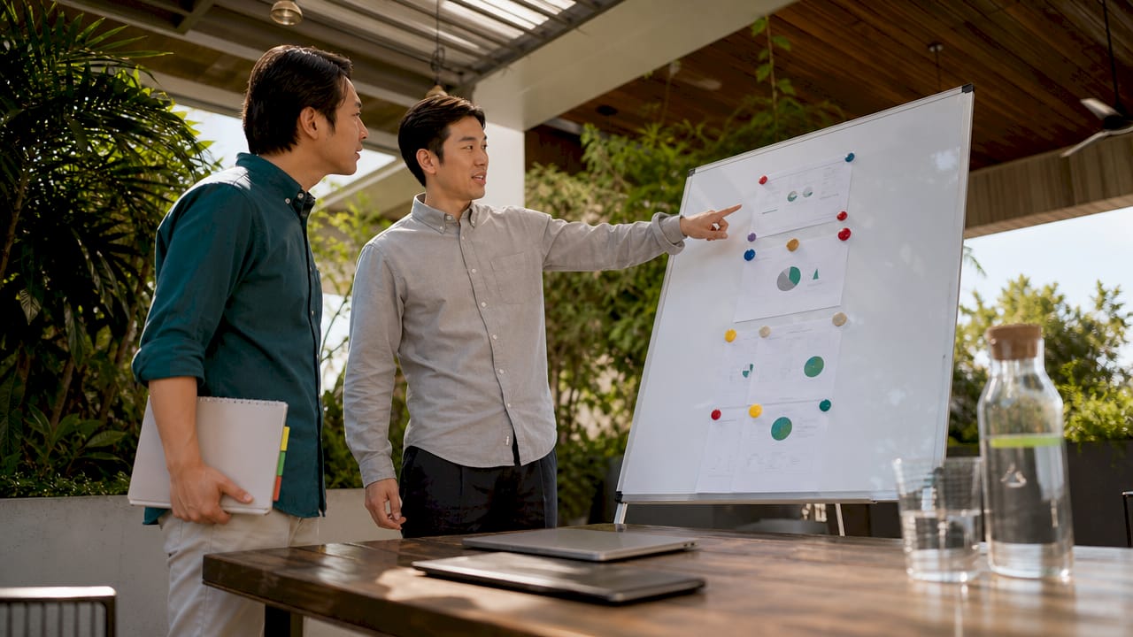 Two men mapping ESG internal data on whiteboard