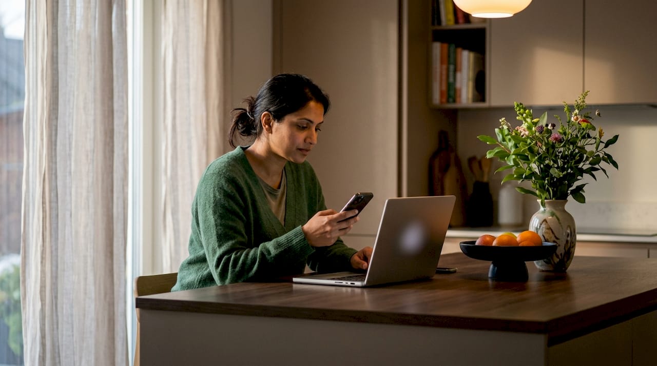 Woman verifying payment page on phone at desk