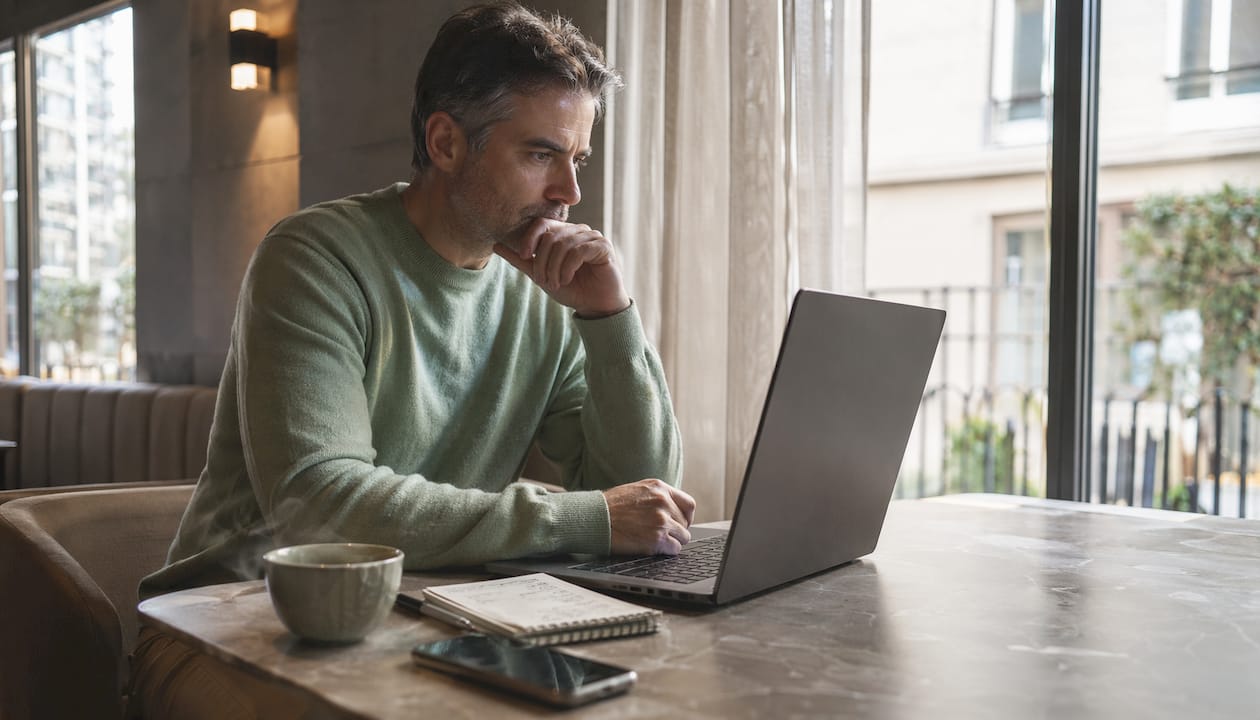 Man verifying website domain on laptop at home