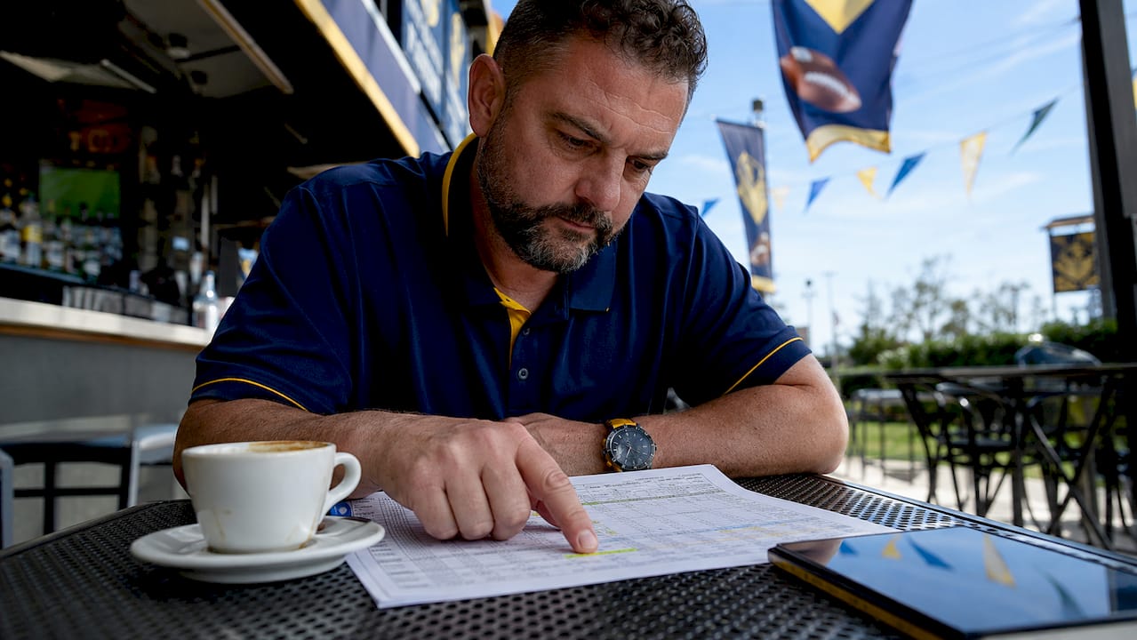Man at sports café reviewing sportsbook odds