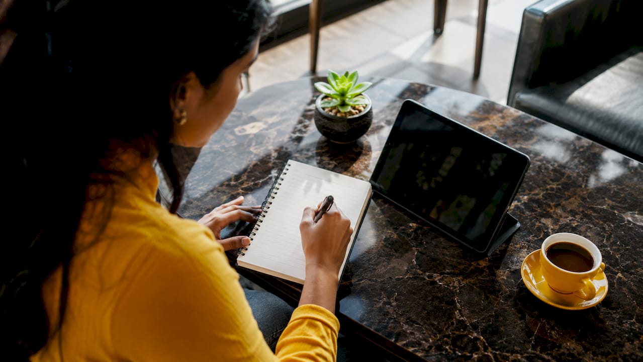 Hands typing on laptop in home betting workspace