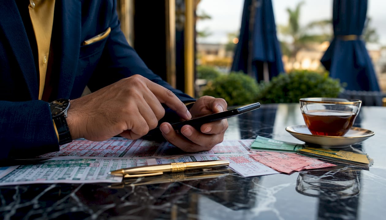 Hands adjusting football betting stakes on smartphone