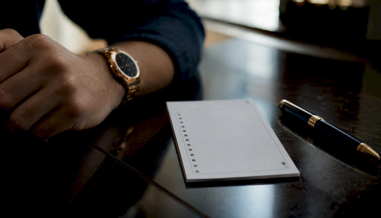 Betting receipt and gold-accented pen on table
