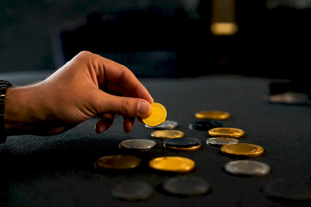 Hand holding gold betting token over table