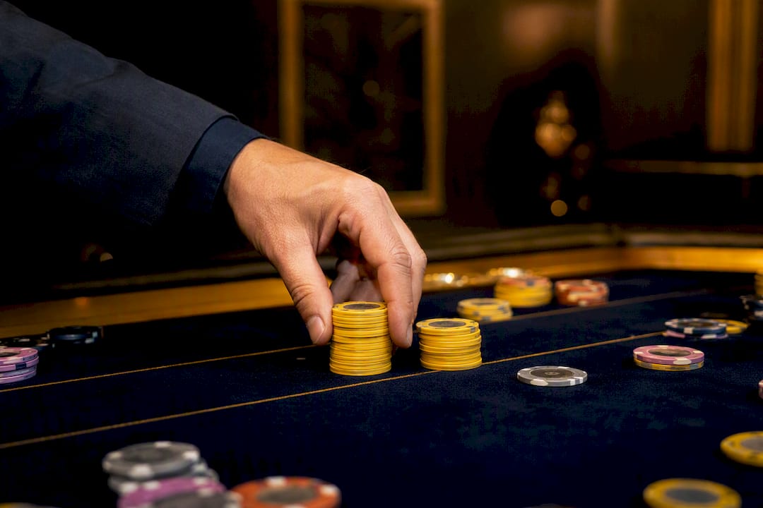 Hand splitting poker chips on felt table