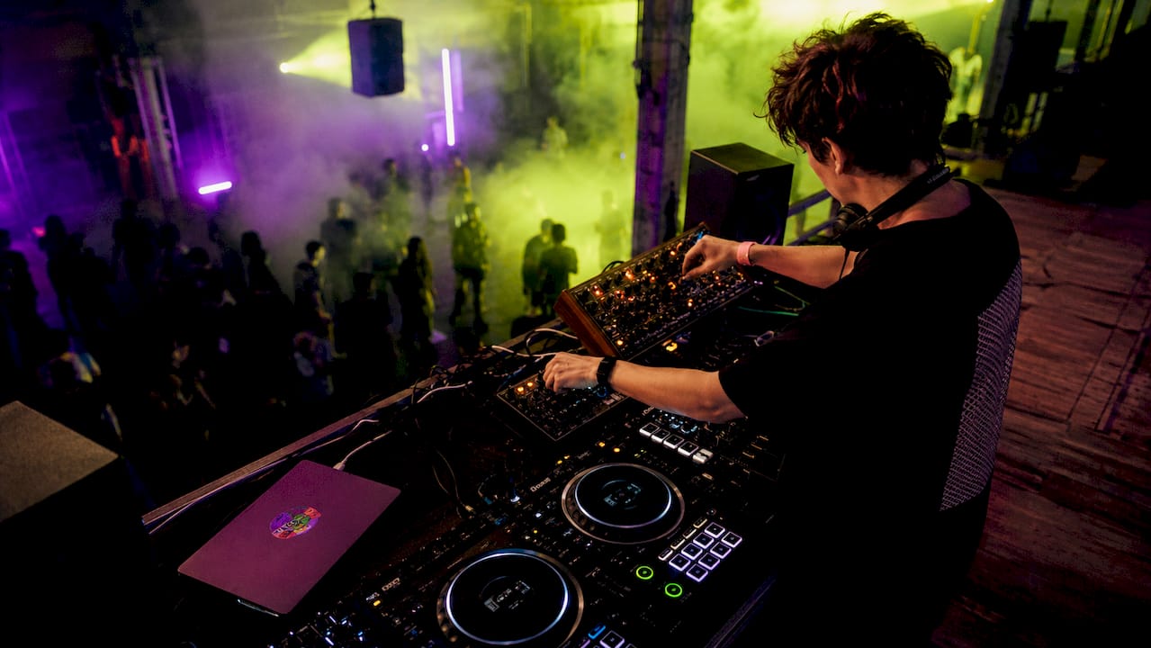 EDM DJ performing with hybrid setup on stage