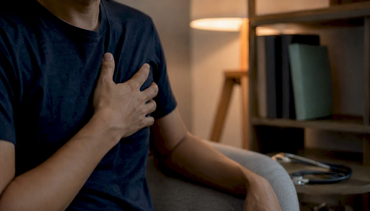 Hand clutching chest indicating heart discomfort