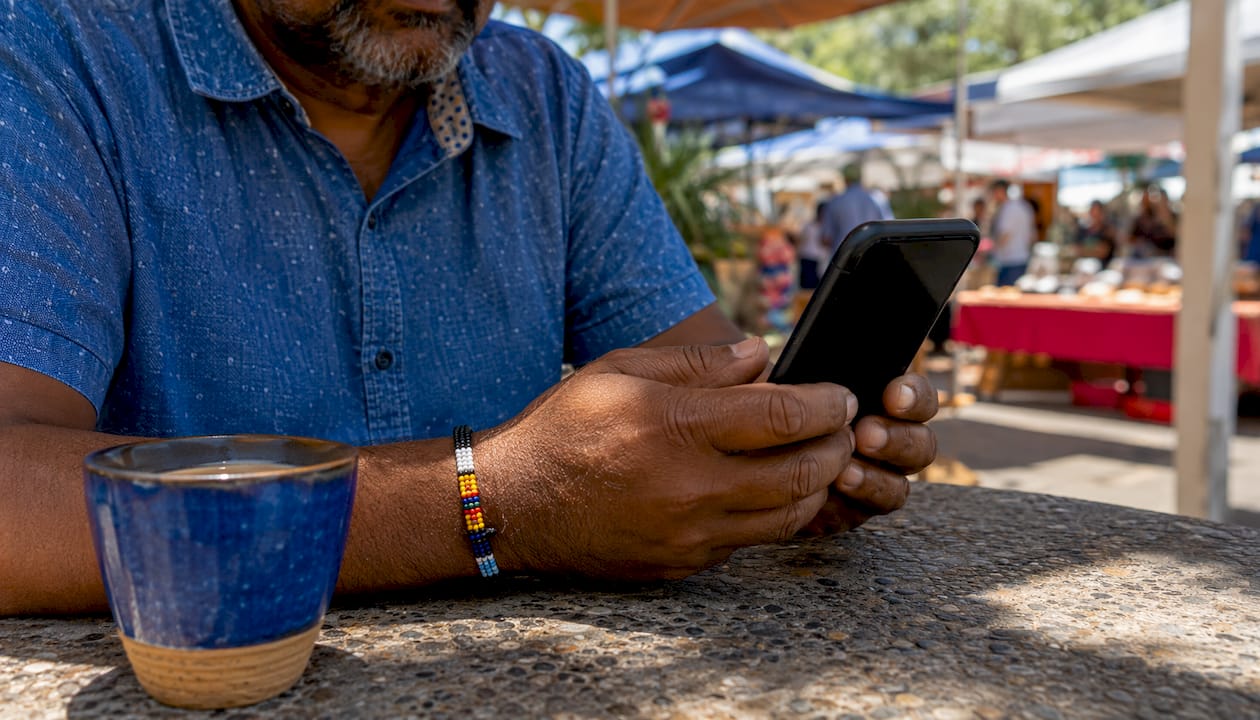 Hands holding phone at café contacting lead