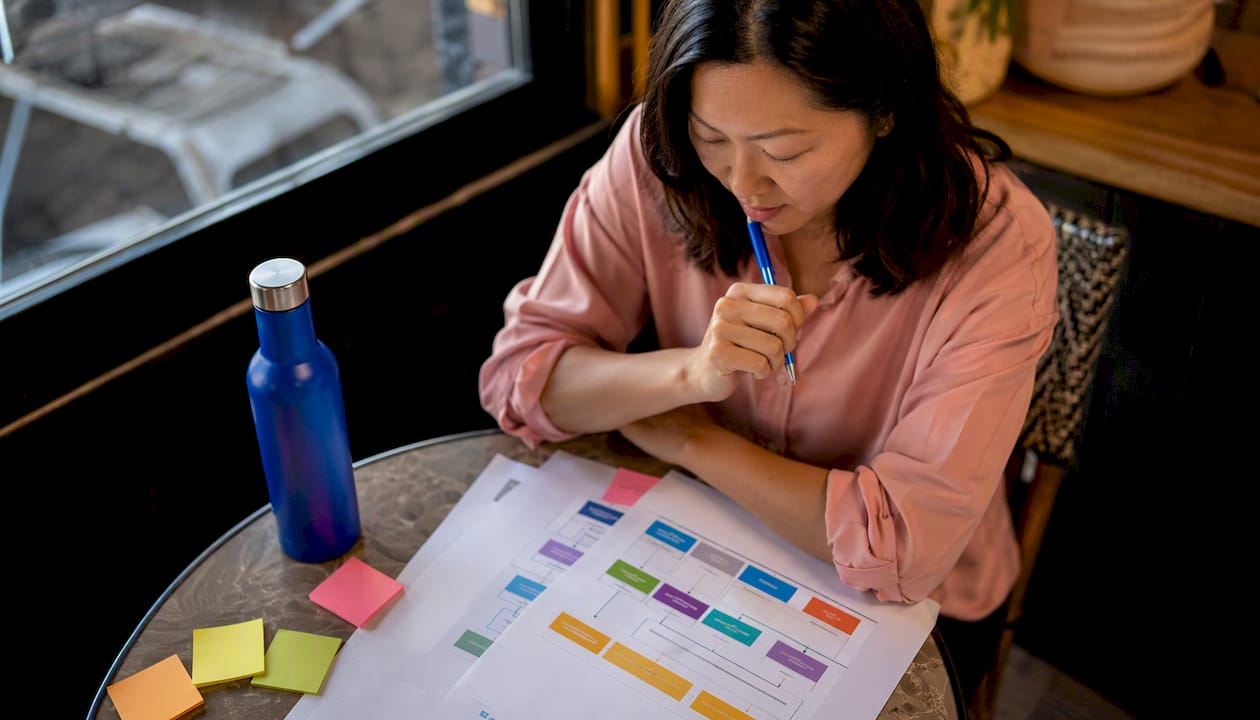 Asian woman reviewing marketing channels in co-working space