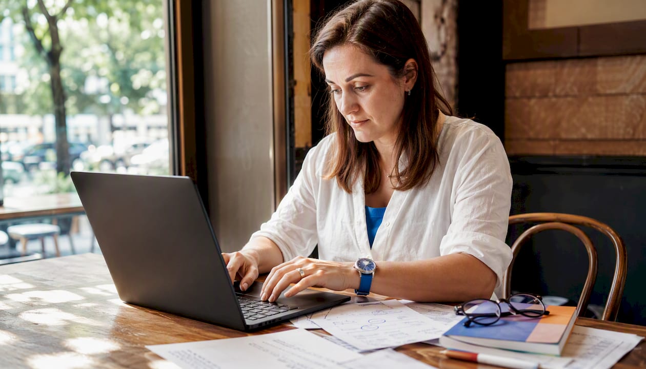 Hands typing and proofreading business documents