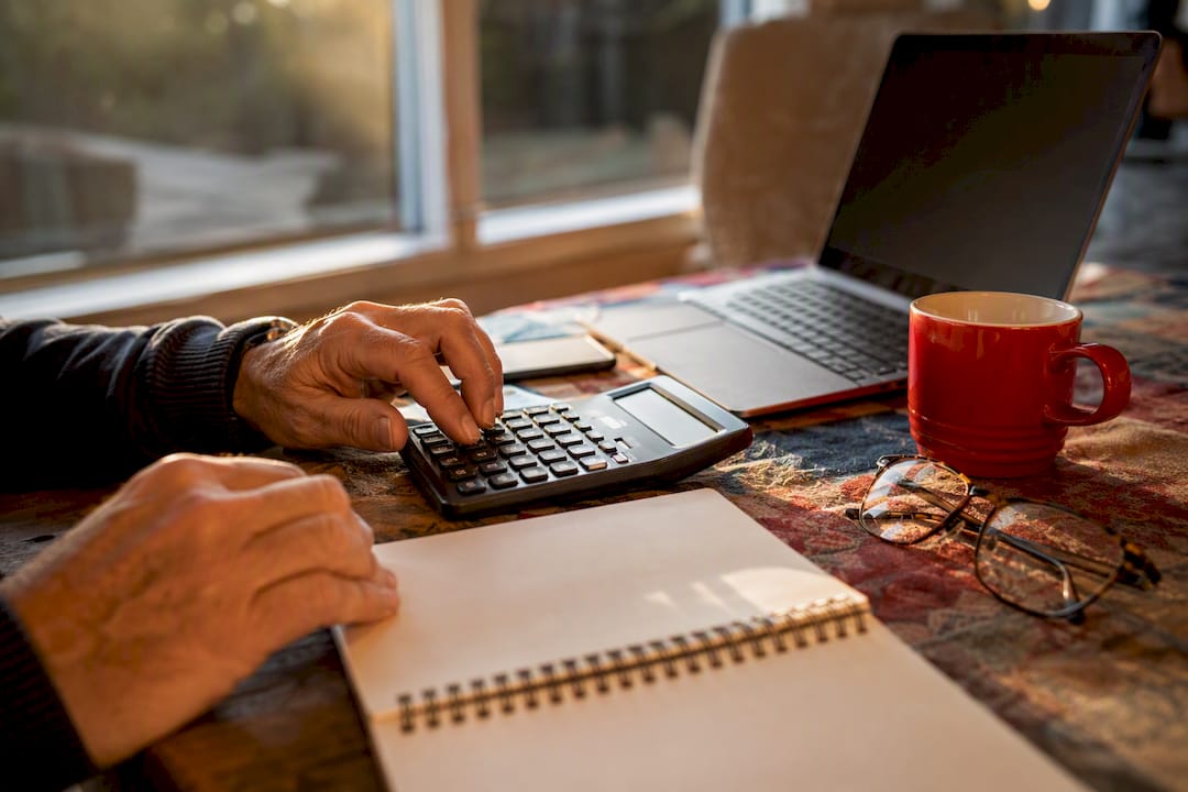 Hands calculating marketing metrics with calculator