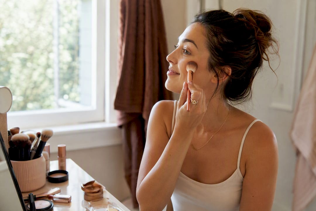 Woman applying setting powder for makeup longevity