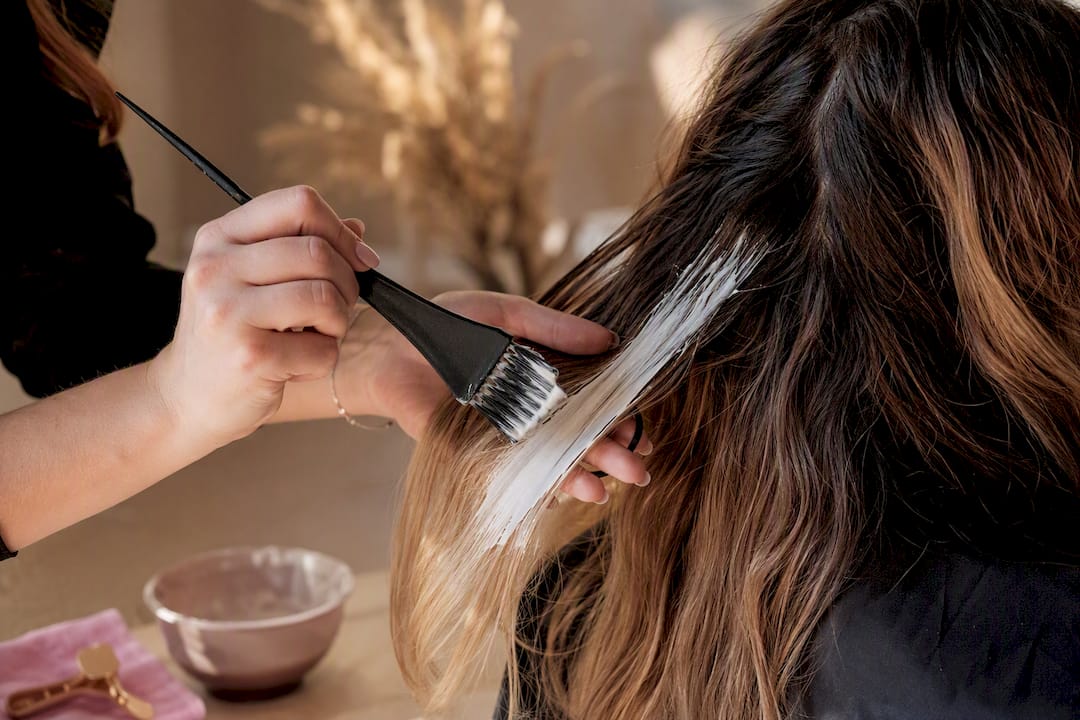 Colorist hand-painting balayage onto hair