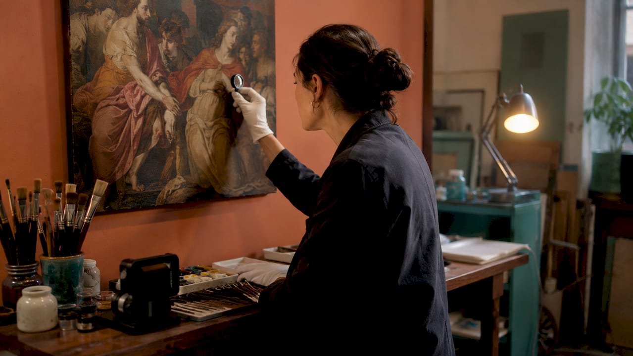 Conservator using UV and infrared tools on painting