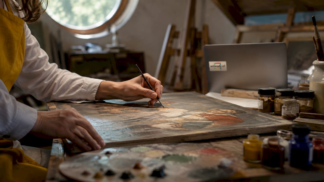 Hands inspecting painting with magnifying glass