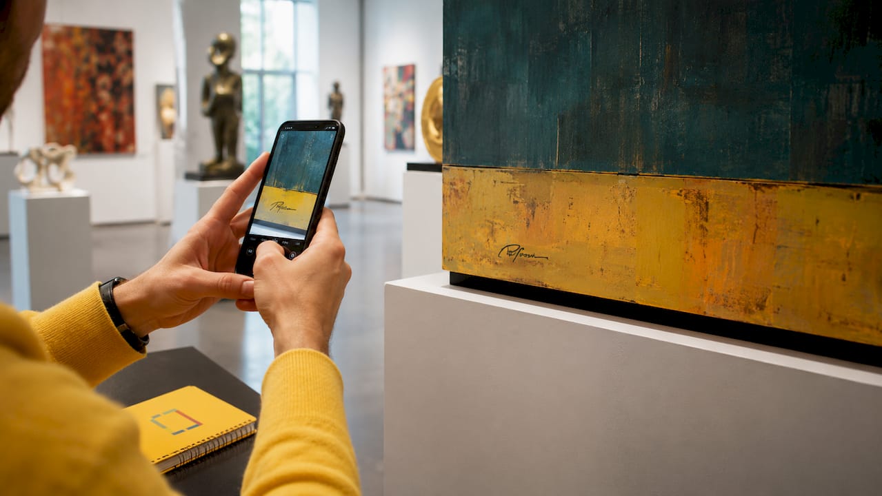 Artist photographing signature on painting in studio