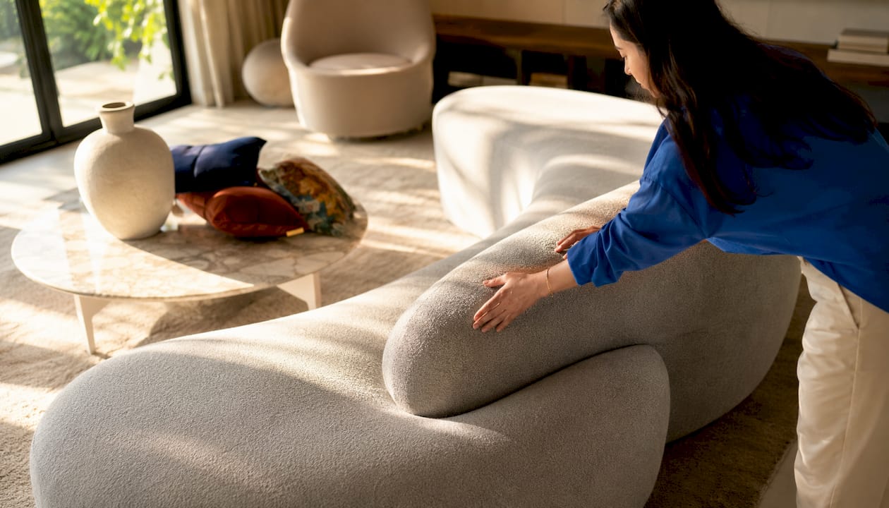 Hands on sculptural curved sofa armrest detail