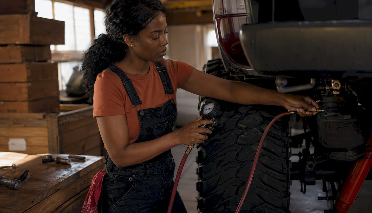 Technician adjusting truck air suspension pressure
