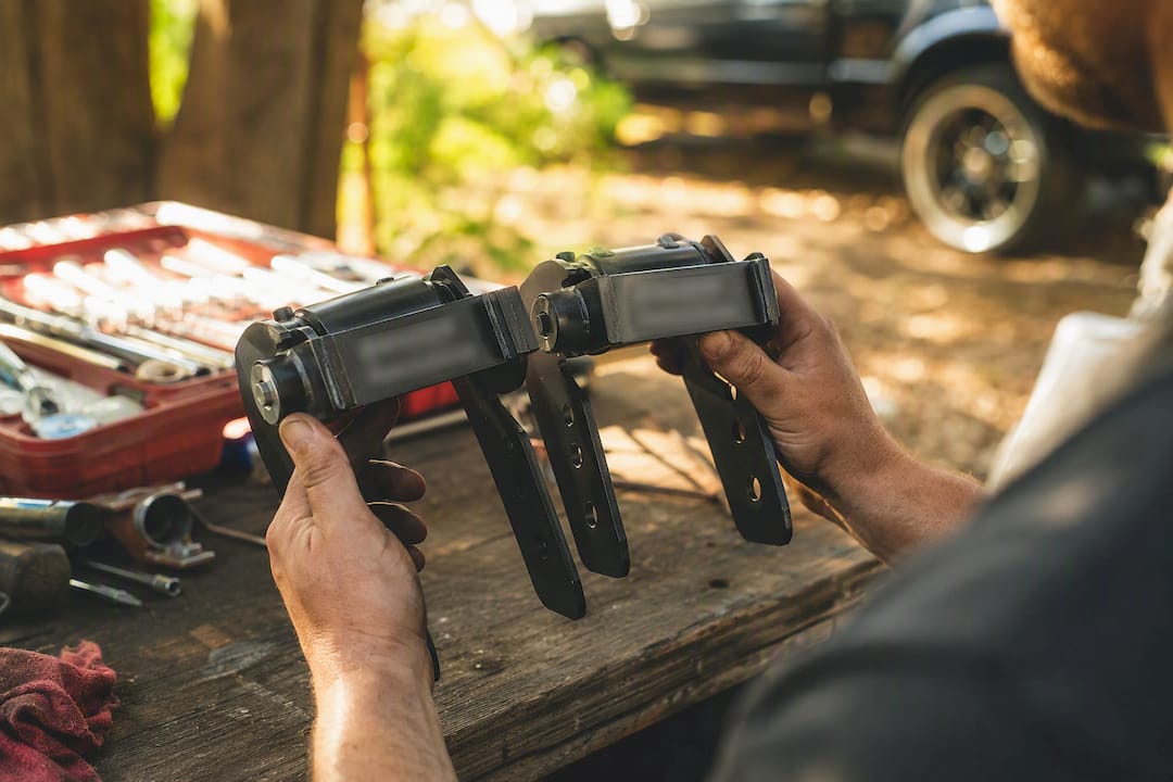 Hands comparing lift kit parts for fitment