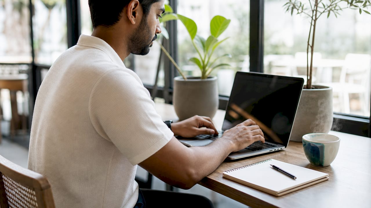 Hands typing on laptop in coworking space