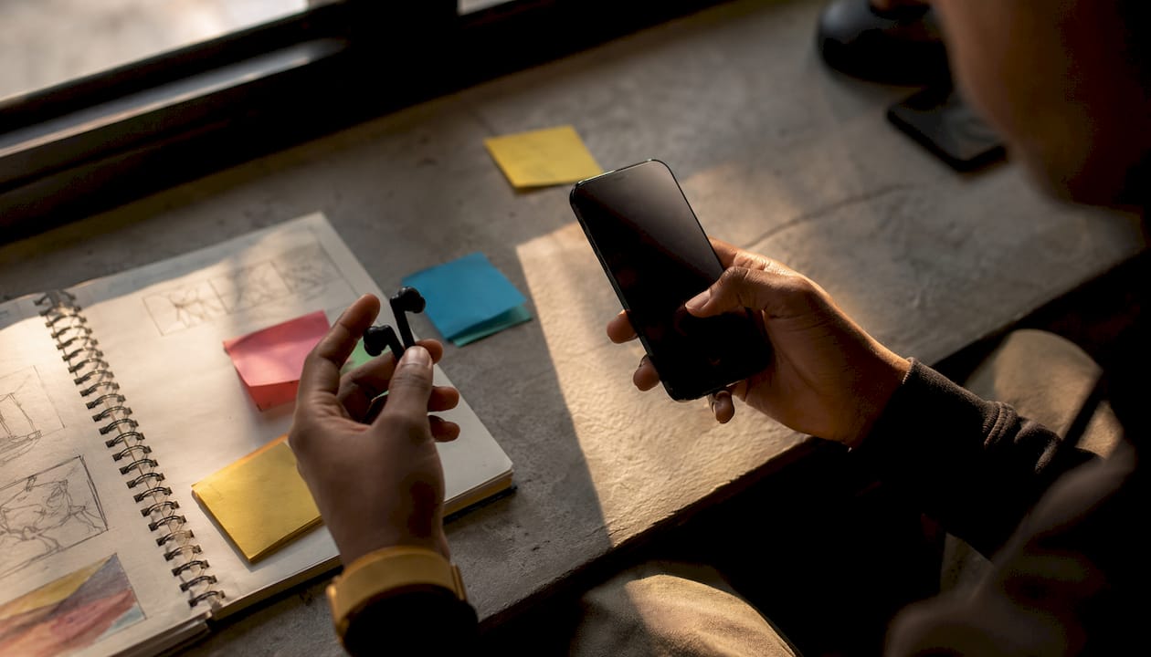 Hands holding headphones and tablet choosing music