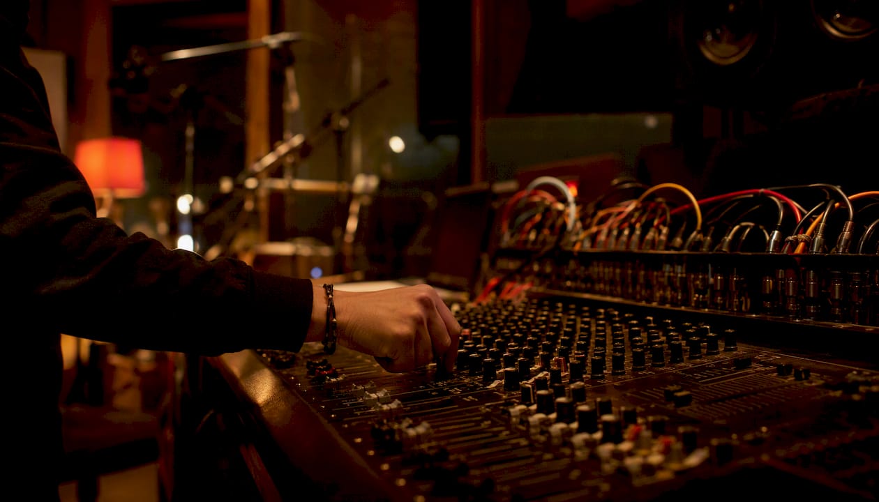 Hand adjusting mixer knob in dim studio