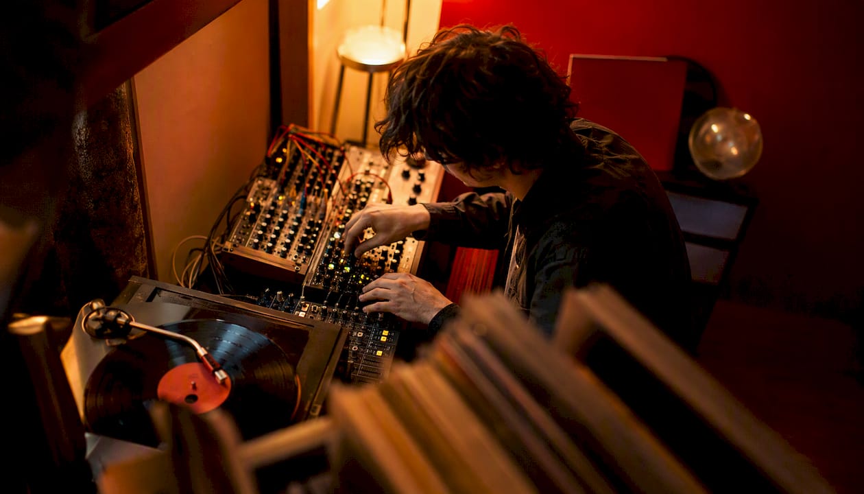 Hands adjusting audio cables in dim music studio