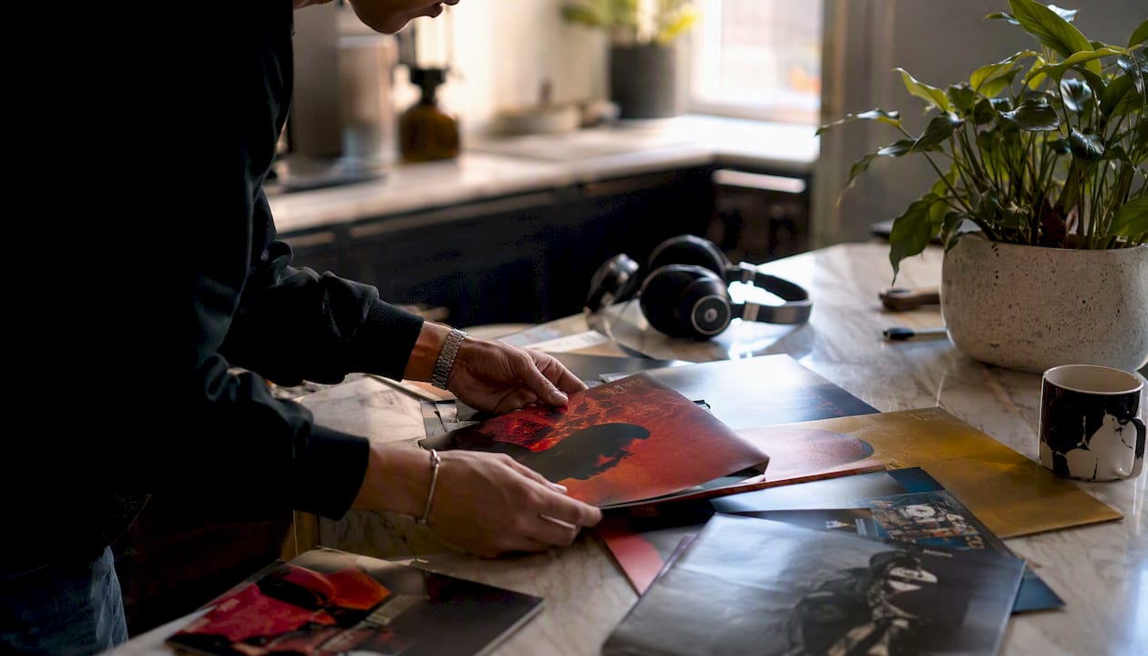 Hands arranging vinyl record covers on table
