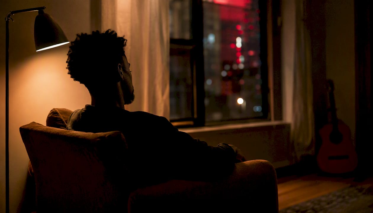 Silhouetted person with headphones in intimate room