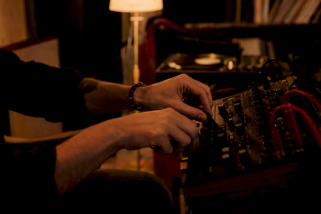 Hands cuing vinyl record on turntable