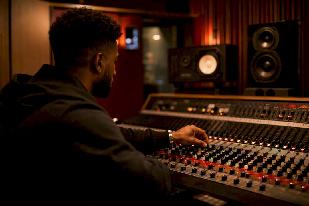Hands adjusting EQ knobs on mixing console