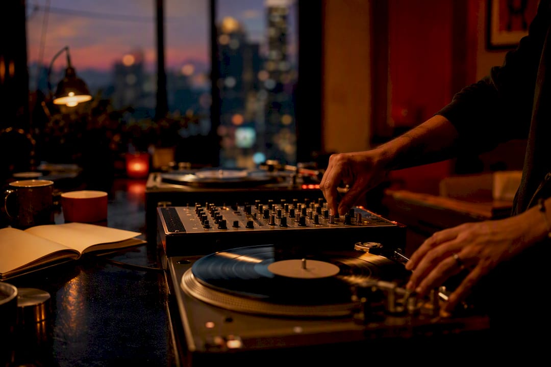 Hands arranging vinyl and mixer in studio