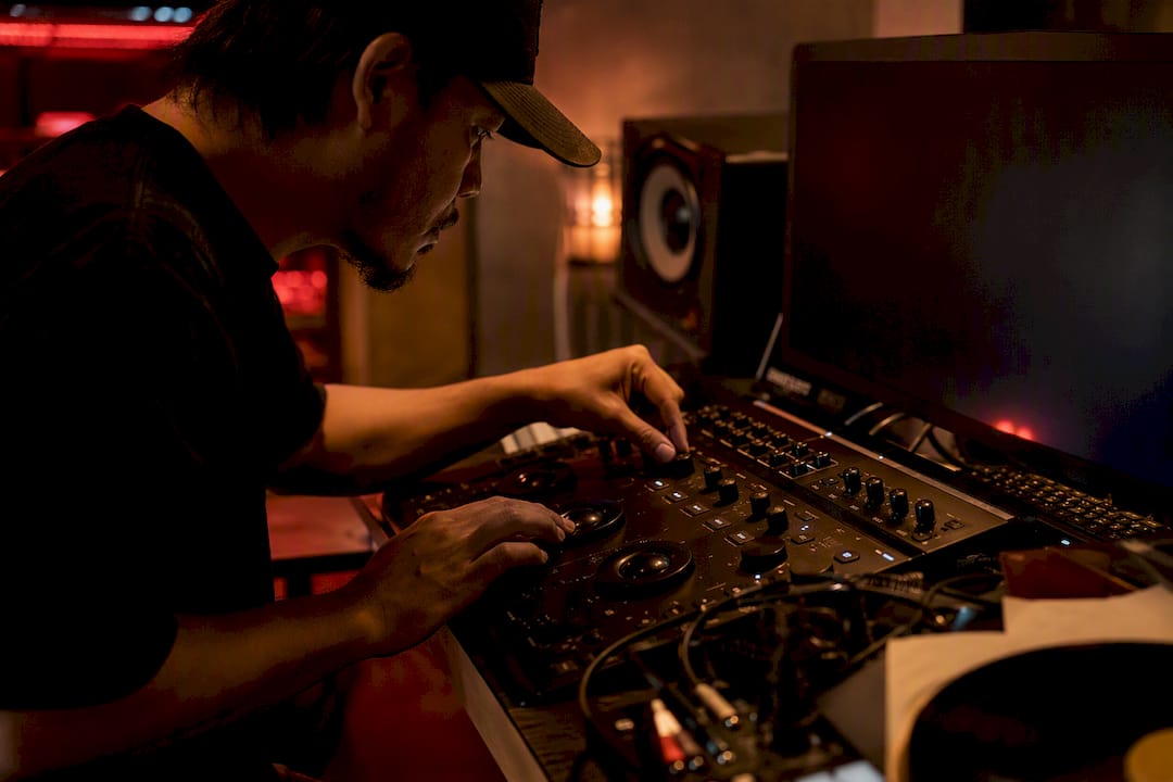 Hands adjusting color grading controls in music studio