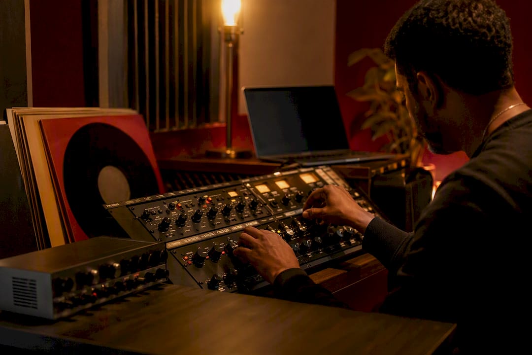Hands adjusting audio mastering equipment