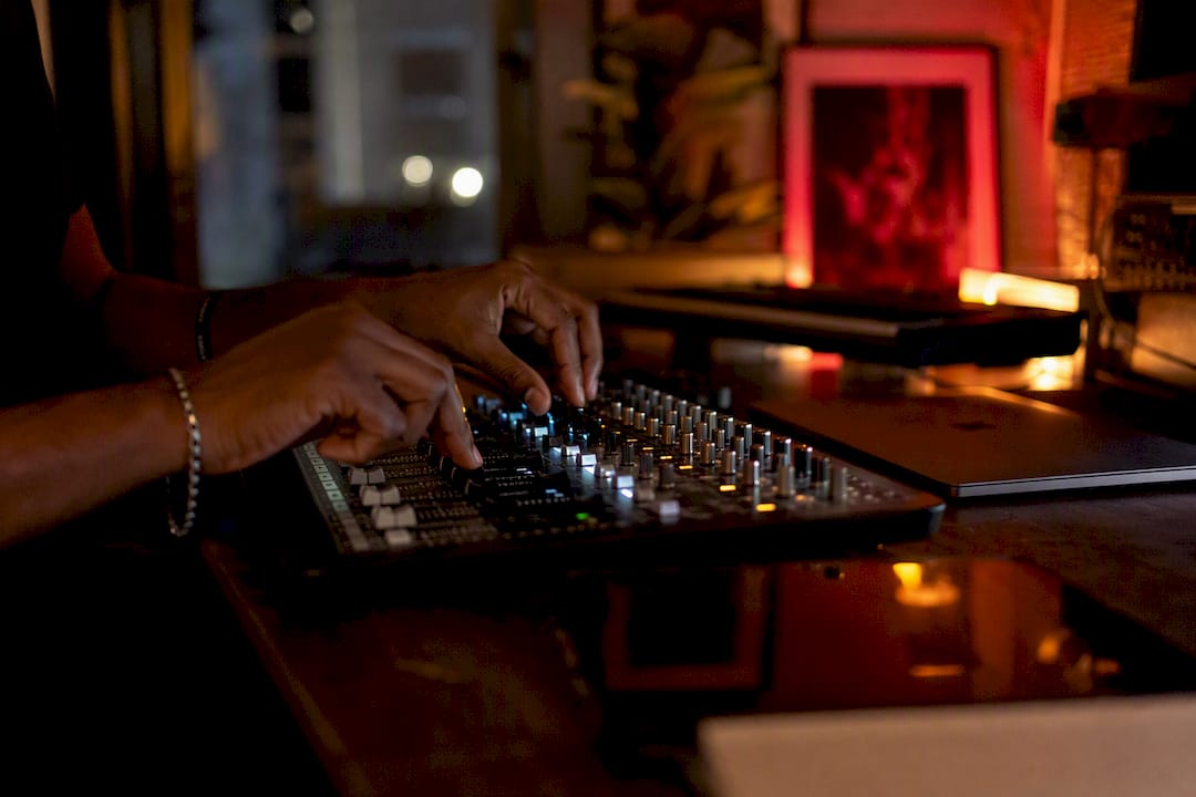 Hands adjusting audio controls in home studio