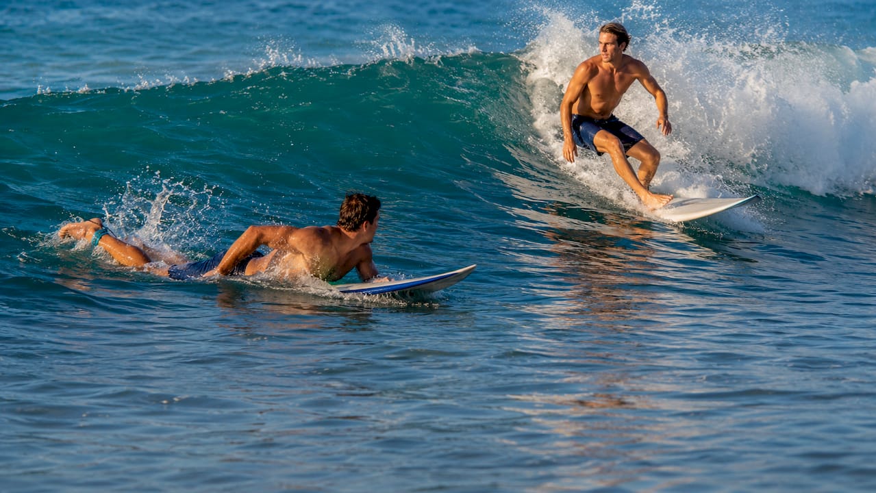 Surfers competing for wave priority in ocean