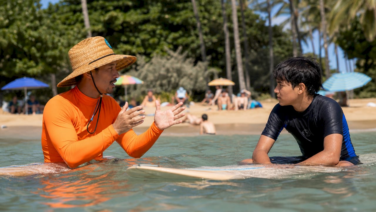 Instructor giving feedback to teen surfer