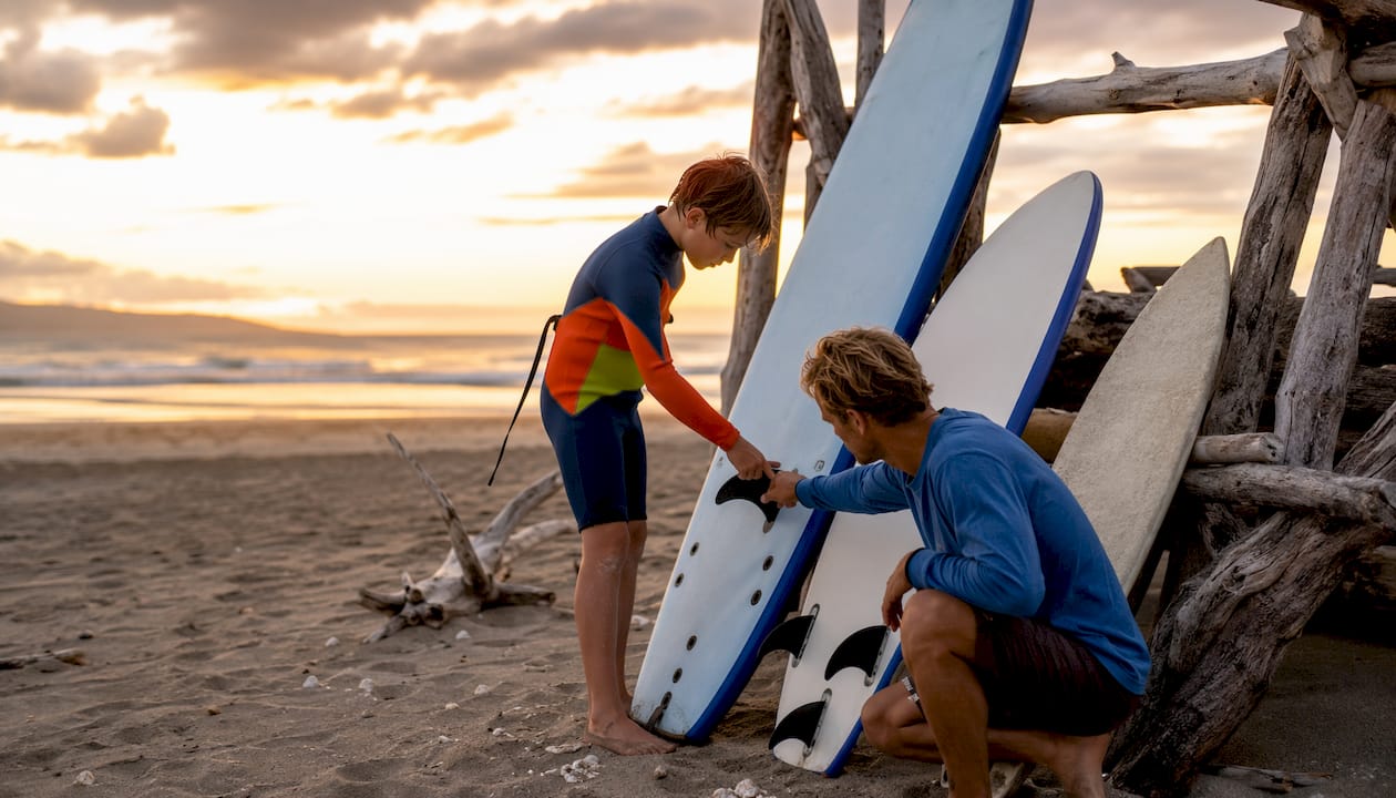 Different sized kids surfboards with child’s hands