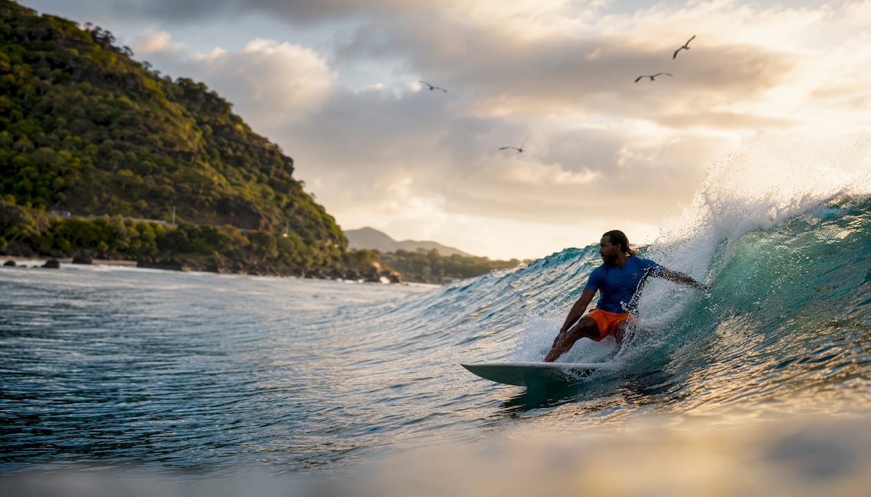 Surfer trimming on wave shoulder in ocean