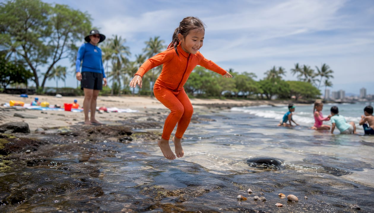 Girl practicing surf readiness balance drill on beach