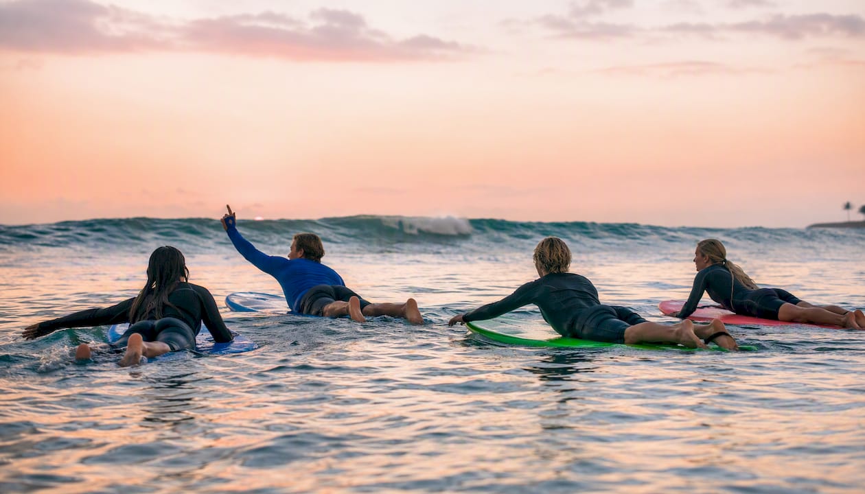 Small group surfing with coach on wave